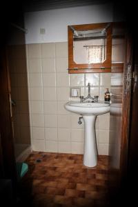 Sálakos尼姆费旅馆的浴室设有白色水槽和镜子