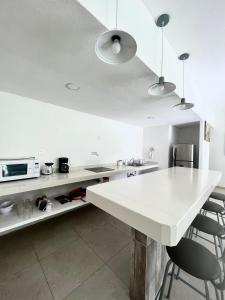 阿卡普尔科Residencial Gran Palma的白色的厨房配有白色的柜台和椅子