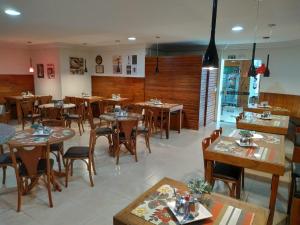 乌穆阿拉马ROMA'S HOTEL的一间设有木桌和椅子的餐厅