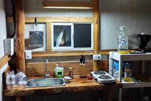 圣玛尔塔GLAMPING BAReKE AZUL2的厨房柜台设有水槽和微波炉