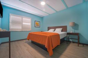洛杉矶NOHO Hotel near Universal Studios Hollywood的一间卧室配有一张带橙色毯子的床