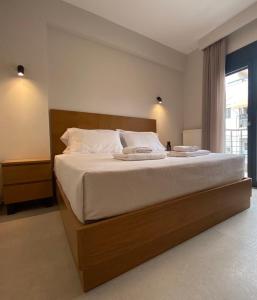 塞萨洛尼基Toumba apartments的卧室配有一张带白色床单的大床和窗户。