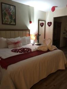米内拉尔德尔蒙特Hotel JYE by Serranillo, Mineral del Monte Hgo的一间卧室配有一张大床,拥有心灵装饰