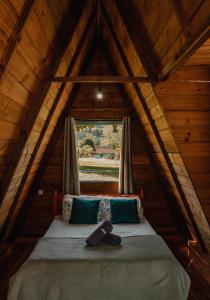 波梅罗迪Recanto do Vale的木制客房的一张床位,设有窗户