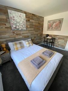 霍利Gatwick Deluxe En-suite Rooms的一间卧室配有一张大床和毛巾