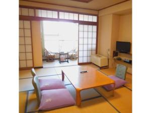 涩川市Ikaho Onsen Sanyo Hotel - Vacation STAY 26406v的客厅配有桌椅
