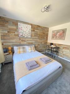 霍利Gatwick Deluxe En-suite Rooms的一间卧室设有一张大床和木墙