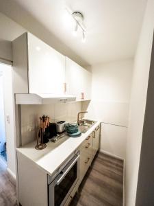 汉诺威Apartment für 3 Gäste mit kostenlosen Parkplätzen und Lift的白色的厨房设有水槽和炉灶。