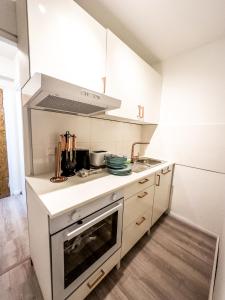 汉诺威Apartment für 3 Gäste mit kostenlosen Parkplätzen und Lift的厨房配有白色橱柜和炉灶烤箱。