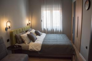 莫斯塔尔Old Town Premium Apartments的卧室配有带枕头的床铺和窗户。
