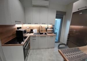 米蒂利尼Doukas Home的厨房配有白色橱柜和水槽