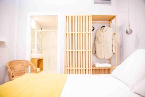 阿罗萨新镇O Legado de Ramira的一间卧室配有衣柜,壁架上装有白色夹克