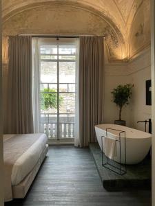 那不勒斯Artemisia Domus - Giardino的一间带浴缸、床和窗户的卧室