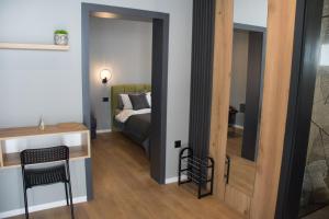 莫斯塔尔Old Town Premium Apartments的一间卧室配有一张床、一张桌子和一面镜子