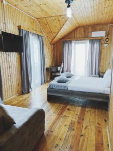谢赫维蒂利Keriya Hotel Shekvetili Kaprovani的客房内设有两张床,铺有木地板,设有窗户。