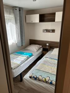 勒米伊Camping les Cigales - Mobil-home 4/6 personnes的带窗户的客房内设有两张单人床。