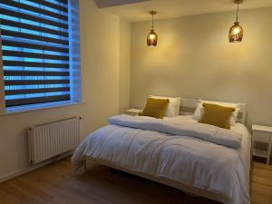 斯沃尼奇SeaViewApartment的一间卧室配有带白色床单和黄色枕头的床。