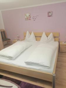 安纳贝格-伦格茨Ferienwohnung Marianne的一张带白色床单和枕头的床