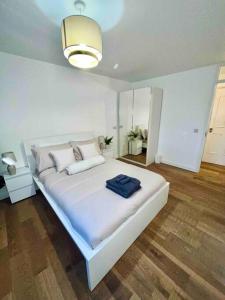 NortholtLovely 1 Bed, Northolt Station的一间卧室配有一张白色大床,上面有蓝色的毛巾