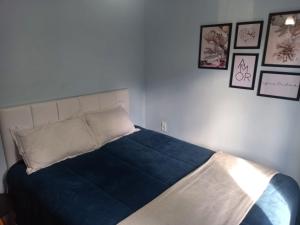 多明戈斯马丁斯Cantin da Mata的卧室内的一张床铺,墙上挂着照片