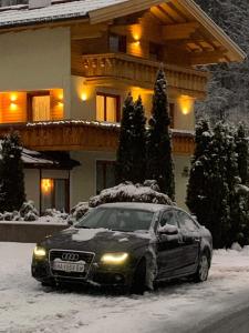 安纳贝格-伦格茨Ferienwohnung Marianne的停在房子前面的雪地里的汽车
