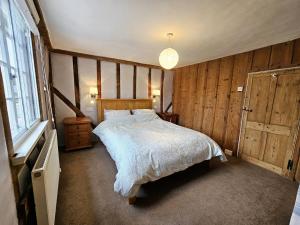 迪斯Perfectly Located Pretty Cottage的一间卧室设有一张大床和一个窗户。