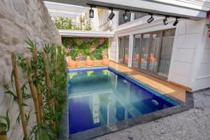 安塔利亚Mrt Suites Lara的一座植物繁茂的房屋后院的游泳池