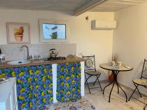 拉古萨码头Rifugio tra gli ulivi的厨房配有带水槽的柜台和2张桌子