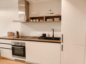 ĶesterciemsBeautiful Seaside apartement Albatross 24的厨房配有白色橱柜和水槽