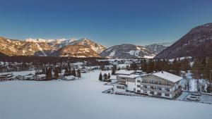皮勒尔湖畔圣乌尔里希Hotel Landhaus Tirolerherz的享有度假胜地的空中景致,该度假胜地拥有雪覆盖的山脉