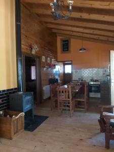 圣卡洛斯-德巴里洛切La Peninsula Cabaña的厨房以及带桌子和炉灶的用餐室