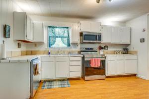 JacksonPeaceful Alabama Vacation Rental with Large Deck的厨房配有白色橱柜、水槽和窗户。