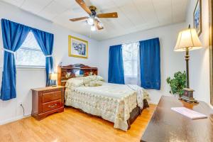 JacksonPeaceful Alabama Vacation Rental with Large Deck的一间卧室配有一张床、一张桌子和蓝色窗帘