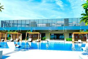 迪拜Paradise on the Island - Luxurious Seaview Apartment @DubaiCreekHarbour的一座带椅子的大型游泳池和一座建筑