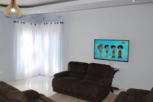 卢萨卡Blue Agave MH的带沙发和平面电视的客厅