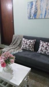 LuqueSaiyú Aeropuerto的客厅配有黑色沙发和白色桌子