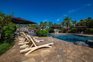 瓦克拉The Islands at Mauna Lani Point - CoralTree Residence Collection的游泳池旁的一排躺椅