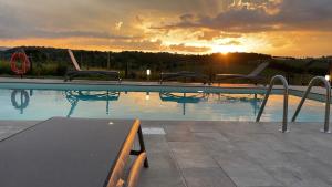 帕西亚诺Agriturismo con cucina Il Favaio的一座享有日落美景的游泳池