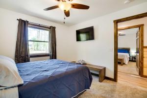 HatfieldVacation Rental Cabin Near Lake Arbutus!的一间卧室配有蓝色的床和吊扇