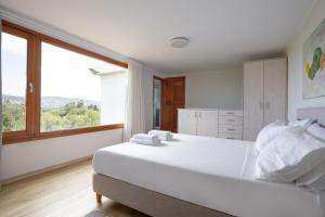 干尼亚Eliva house的卧室设有一张大白色的床和大窗户