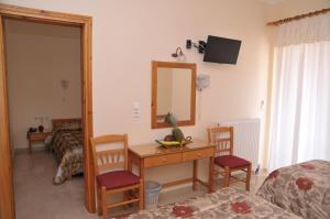 阿尔库季岛Brati II Beach Hotel的客房设有一张桌子、两把椅子和一面镜子