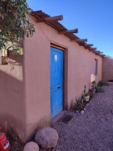 圣佩德罗·德·阿塔卡马Cabañas Rica-Rica Lodge的房子边的蓝色门