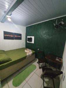 蒙加瓜Pousada das Artes 1的卧室配有一张床和一张桌子及椅子