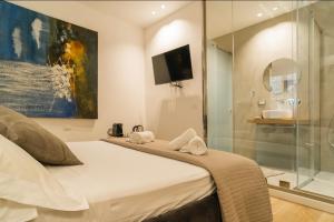 巴勒莫Four Luxury Suite的一间卧室设有一张床和一个玻璃淋浴间
