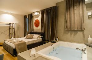 巴勒莫Four Luxury Suite的带浴缸和床的酒店客房