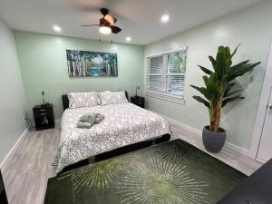 希尔顿黑德岛Tranquility in paradise- 2 bedroom villa w/parking的一间卧室配有一张床和盆栽植物