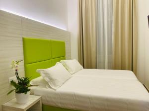 米兰Hotel Fioralba的一间卧室配有一张白色床和绿色床头板
