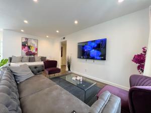 洛杉矶Hollywood Purple Habitat的客厅配有沙发和墙上的电视