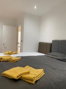 伦敦Luxury Flat Near Greenwich Park的一间卧室配有一张带两张黄色毛巾的床