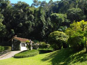 彼得罗波利斯Canto do Bosque - Chalé Sabiá com hidromassagem的郁郁葱葱的绿色庭院中的房子